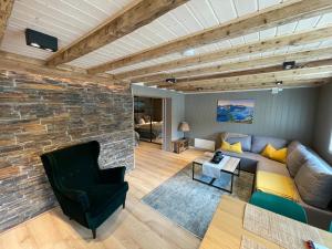 a living room with a couch and a stone wall at Lofoten Planet Studio in Sørvågen
