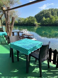 a table and chairs on a patio next to a lake at Hotel River View bihac in Lohovo