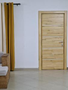 a wooden door in a room with a couch at Appartments Meuble SEED in Yaoundé +3 photos