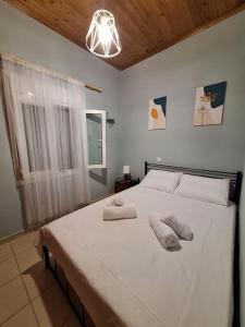 um quarto com uma grande cama branca com duas almofadas em Lovely Guesthouse On The Beach em Agia Anna
