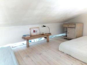 ein Schlafzimmer mit einem Bett und einem Tisch mit einer Lampe in der Unterkunft Gorgeous art loft - 5 minutes from the sea in Vari