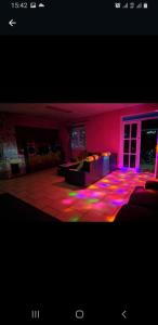 - un salon avec des lumières violettes et roses au sol dans l'établissement Villa pondok nurul, à Cilember Udik 1