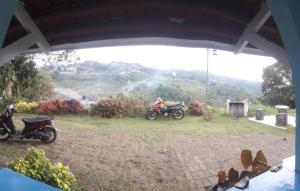 deux motocycles garés dans un champ voisin dans l'établissement Villa pondok nurul, à Cilember Udik 1