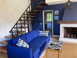 a blue couch in a living room with a staircase at Casa Senda de los Miradores in Muros de Nalón +79 photos