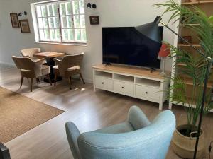 a living room with a tv and a chair and a table at Casa Senda de los Miradores in Muros de Nalón
