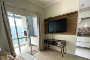 a living room with a flat screen tv on the wall at Maison Azuos - Charme e mar em perfeita harmonia! in Ubatuba