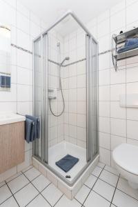 a bathroom with a shower and a toilet and a sink at Ferienwohnung Inselblick in Bensersiel