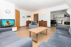 a living room with a couch and a table and a tv at Ferienwohnung Inselblick in Bensersiel +15 photos