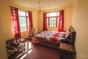 a bedroom with a bed and two windows at Spiti Homestay by StayApart in Spiti