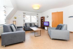 a living room with two couches and a tv at Ferienwohnung Inselblick in Bensersiel