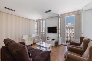 salon z kanapą, krzesłami i telewizorem w obiekcie BNBHolder Apartamentos en Sol Deluxe 1 w Madrycie
