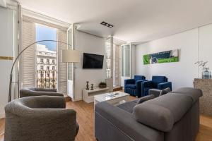 sala de estar con sofá, sillas y TV en BNBHolder Apartamentos en Sol Deluxe 3, en Madrid