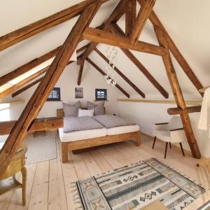 a attic room with a bed and a chair at Ankommen, Wohlfühlen und die Natur genießen in Lichtenhain
