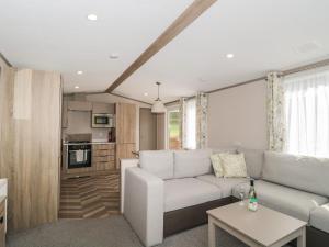 a living room with a couch and a table at Lodge 11 in Winscombe