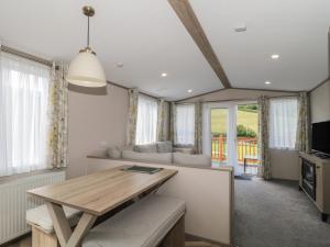 a living room with a table and a couch at Lodge 11 in Winscombe