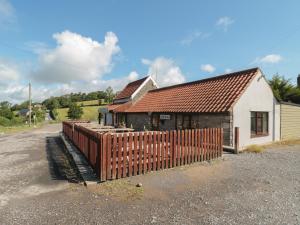 a building with a fence in front of it at Lodge 9 in Winscombe