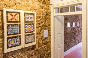 a stone wall with some mosaics on a wall at inBraga Hostel in Braga