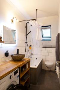 La salle de bains est pourvue d'un lavabo, d'une baignoire et de toilettes. dans l'établissement Renoviertes Design Apartment mit Toller Terasse, à Mülheim
