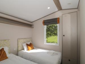 um quarto com 2 camas e uma janela em Lodge 10 em Winscombe