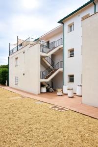 a white building with stairs and a yard at Sa Conca in S'agaro