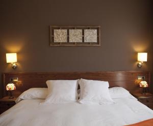 a bedroom with a white bed with two pillows at Hotel & Spa Can Josep in Bot