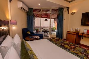 Habitación de hotel con cama, mesa y sillas en GANGA KINARE- A Riverside Boutique Resort, Rishikesh, en Rishīkesh