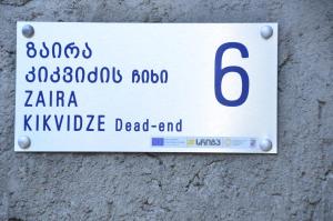 un cartello su un muro con il numero di Phudze a Telavi