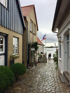 eine Kopfsteinpflasterstraße zwischen zwei Gebäuden mit einer Flagge in der Unterkunft Ferienwohnung Seemöwe in Schleswig
