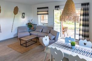 ein Wohnzimmer mit einem Sofa und einem Tisch in der Unterkunft Ferienhausanlage Sonne in Dranske