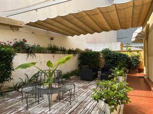 un patio con mesa, sillas y plantas en Hospederia Imar en Cádiz