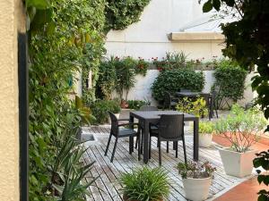 une terrasse avec une table, des chaises et des plantes dans l'établissement Hospederia Imar, à Cadix