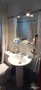 ein Badezimmer mit einem Waschbecken, einem WC und einem Spiegel in der Unterkunft MARGARET VACATION HOUSE 52 in Kamena Vourla