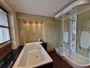 a large bathroom with a tub and a shower at Laurentius Boutique-Hotel & Restaurant in Weikersheim