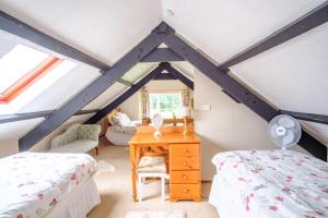 a bedroom with two beds and a desk with a mirror at Lakeside Cottage in Carmarthen