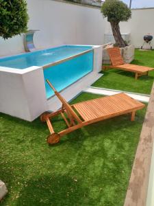 una piscina con 2 sillas y un banco al lado en Casa de Moledo, en Moledo