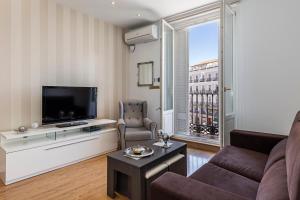 sala de estar con sofá y TV en BNBHolder Apartamentos en Sol Superior 1 en Madrid