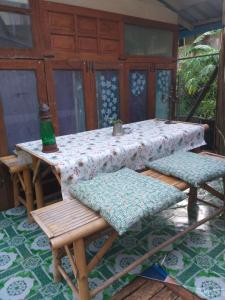een tafel en twee stoelen met een tafel en een fles bij Pikban in Chiang Rai