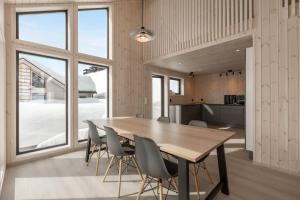a dining room with a wooden table and chairs at Hodlekvevegen 308 - Flott hytte midt i skisenteret in Sogndal
