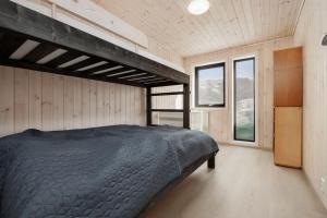 a bedroom with a bed in a room with windows at Hodlekvevegen 308 - Flott hytte midt i skisenteret in Sogndal