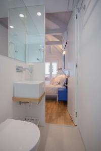 a bathroom with a sink and a toilet and a bedroom at Downtown Cosy Suite V in Porto