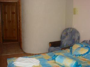 a bedroom with a bed and a blue chair at Complex Korop in Sredneye