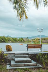 a bench sitting on a dock next to a body of water at Between 2 waters Villa, free rental car offered. in Tamarin