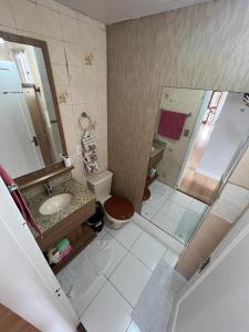 a bathroom with a toilet and a sink and a shower at Ap 3 qts, a suíte e mais 1 qt com split in Bento Gonçalves