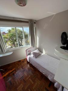 a bedroom with a bed and a large window at Ap 3 qts, a suíte e mais 1 qt com split in Bento Gonçalves
