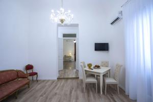 salon ze stołem, krzesłami i żyrandolem w obiekcie Terre d'oro, appartamento di lusso in centro città w mieście Palermo