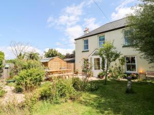 a large white house with a garden and a yard at Pentira in Helston