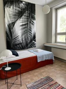 ein Schlafzimmer mit einem Bett mit einem großen Gemälde an der Wand in der Unterkunft Tapanilan Huoneistot in Lahti