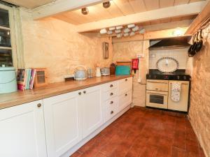 a kitchen with white cabinets and a stove at Pentira in Helston