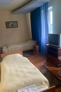 a living room with a bed and a television at Complex Korop in Sredneye