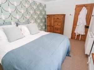 a bedroom with a large bed and a dresser at Pentira in Helston